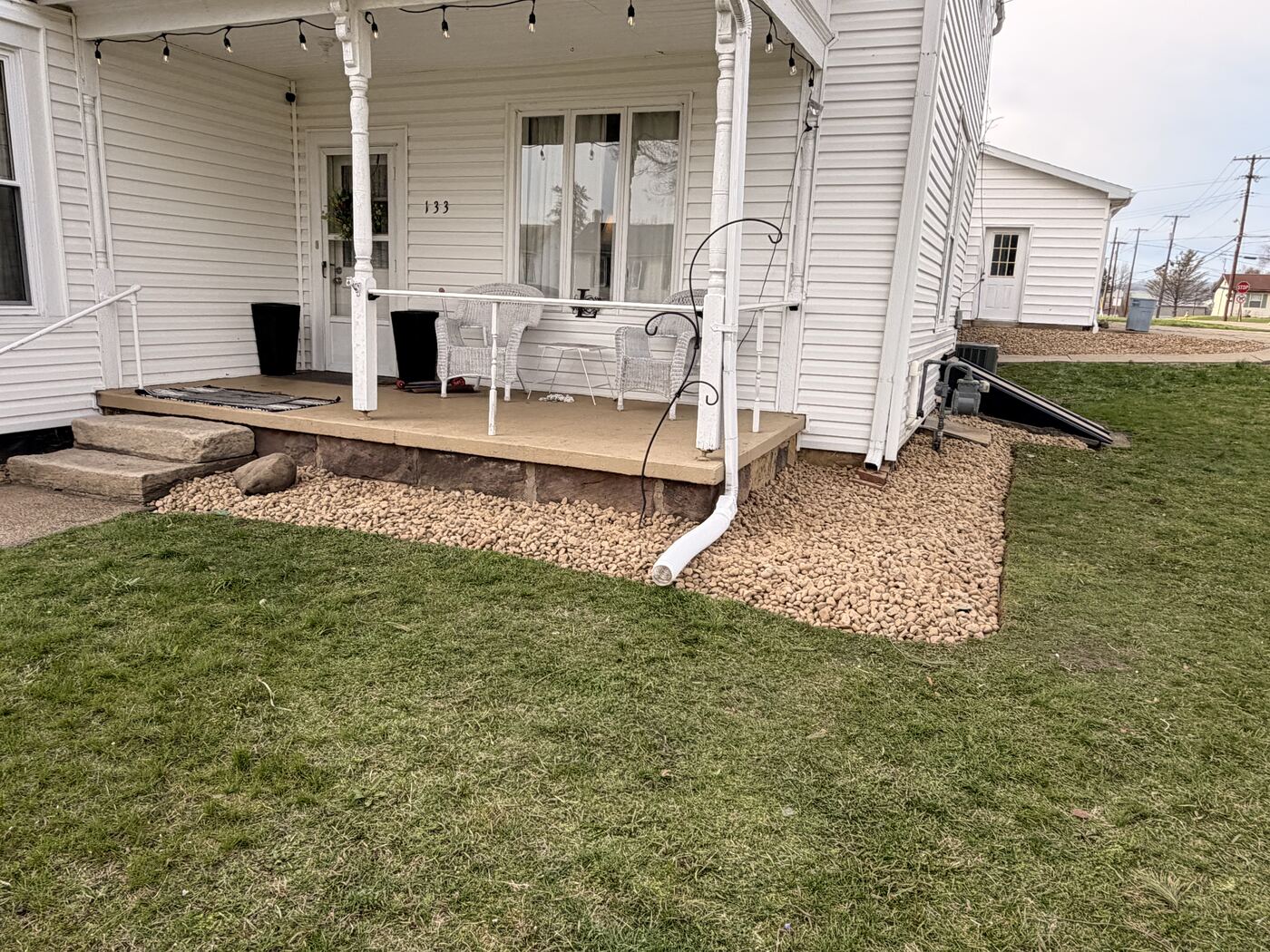 River rock bed under a front porch with stone step