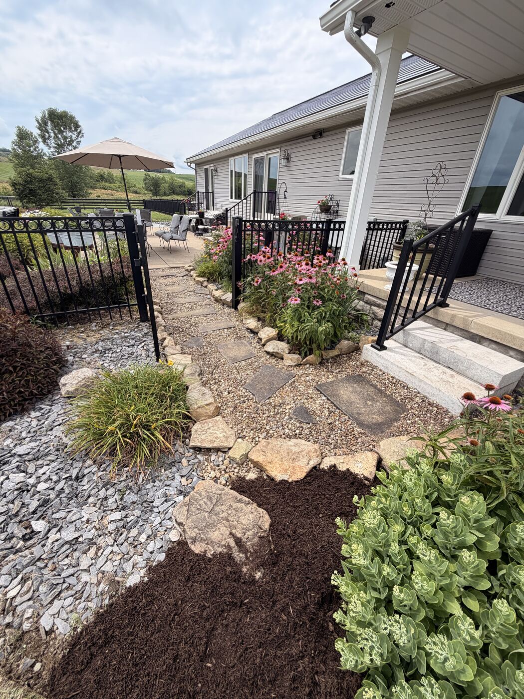 Stone pathway with boulder accents and perennial plantings