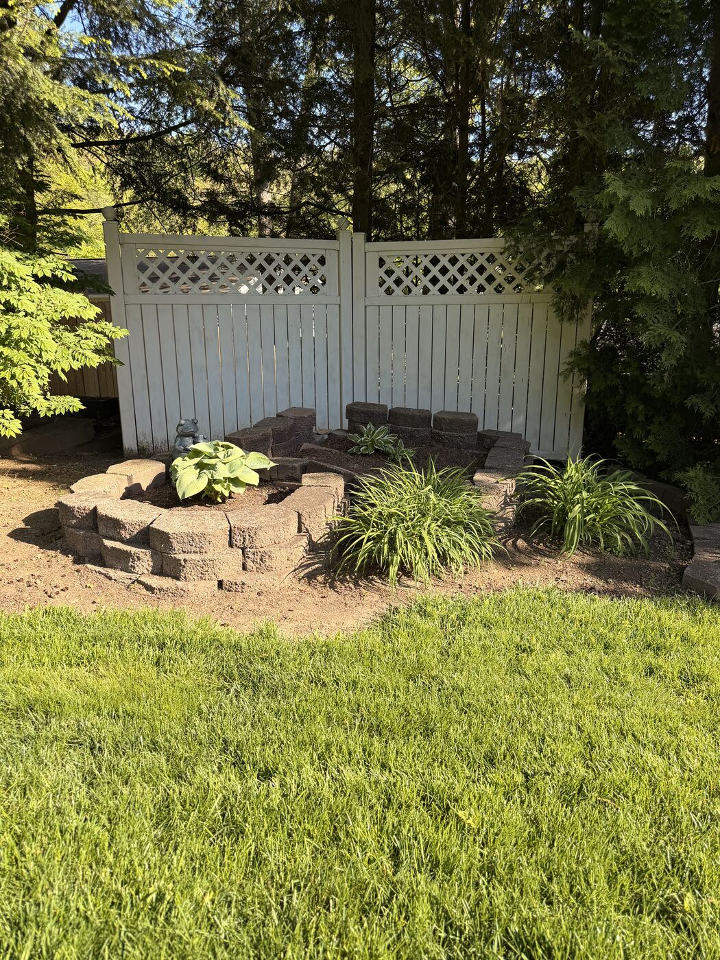 Tiered raised landscape bed with hostas and ornamental grasses